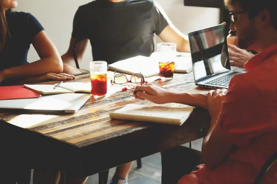 Equipo de una agencia reunido trabajando con portátiles